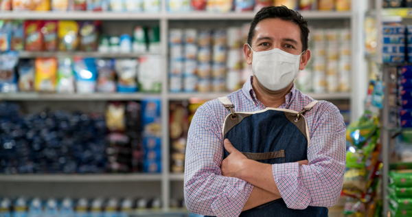 Business owner working at a grocery store wearing a facemask